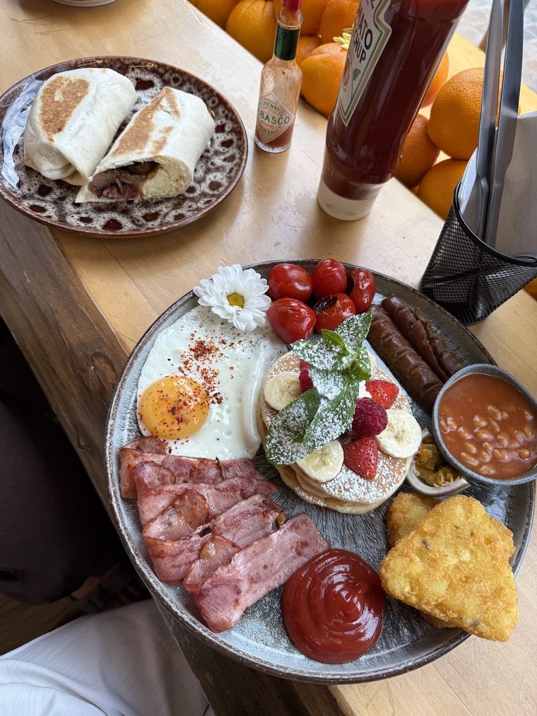 Full English platter with sausage, bacon, egg, hash brown, beans and pancakes