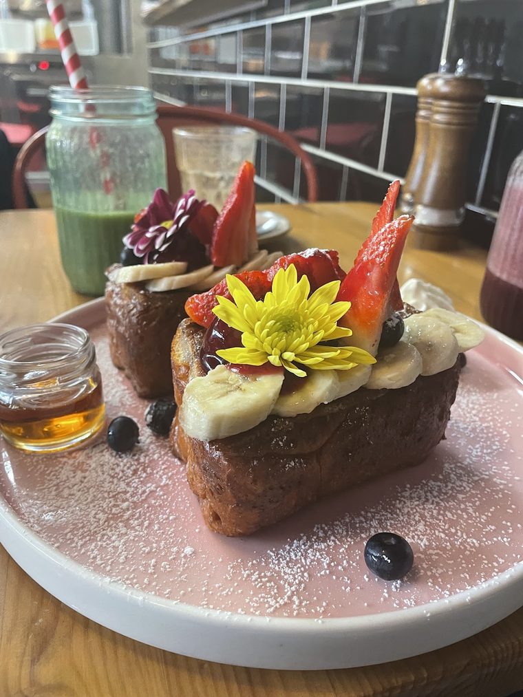 French toast topped with banana and strawberry, dusted with sugar